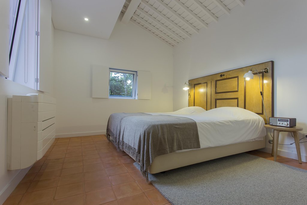 House accommodations/lodging at Quinta dos Peixes Falantes: a large, spacious, elegant modern bedroom with door-frame headboard