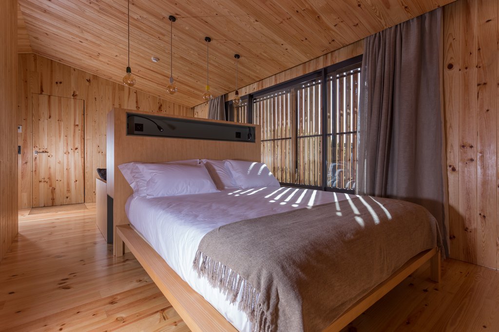 Studio accommodations/lodgings at Quinta dos Peixes Falantes: elegant bedroom finished in rich wood with large bed